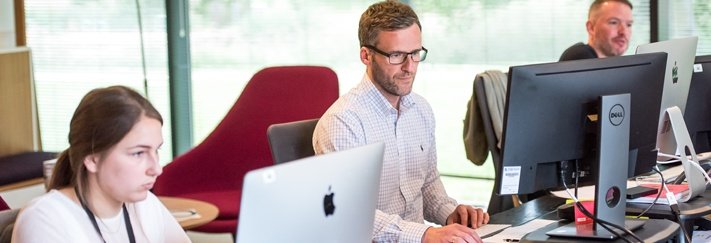 People working at computers in a bright open office